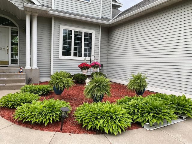 property entrance featuring a shingled roof