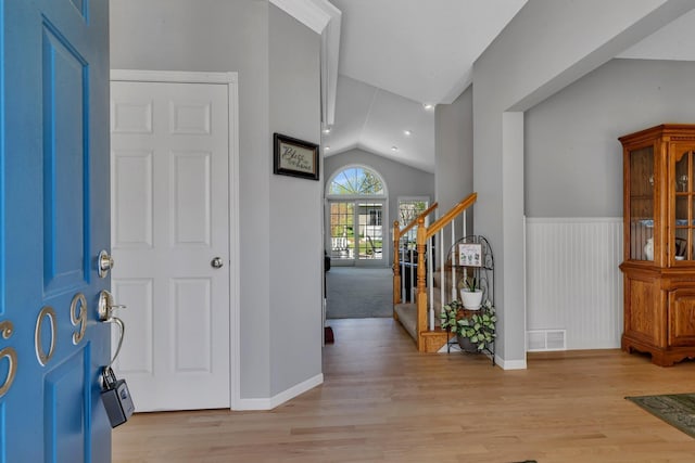 1609 26th St SE, Saint Cloud, MN 56304 - foyer entrance with vaulted ceiling, light wood finished floors, baseboards, stairway, and wainscoting