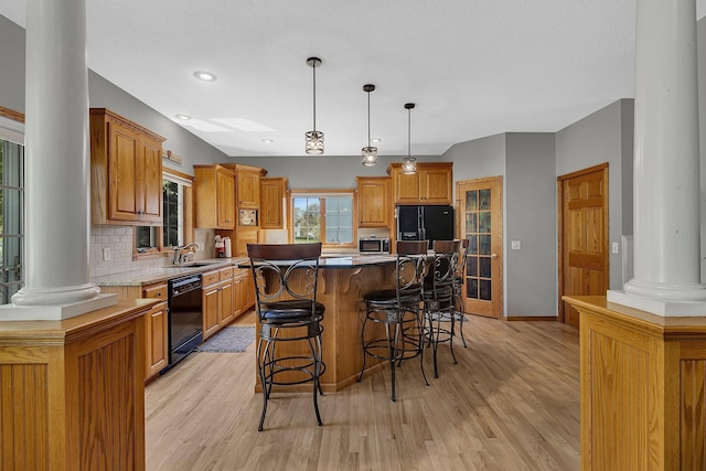 1609 26th St SE, Saint Cloud, MN 56304 - kitchen with ornate columns, black appliances, a sink, a breakfast bar area, and backsplash