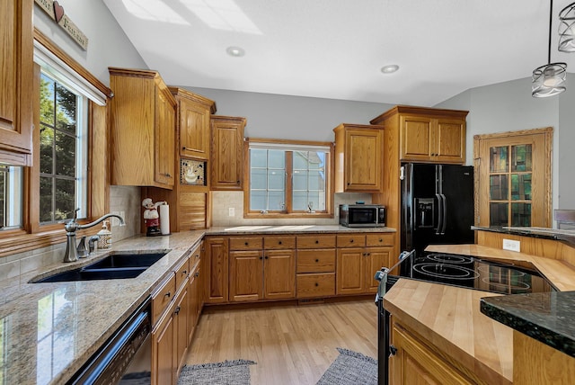 1609 26th St SE, Saint Cloud, MN 56304 - kitchen with black appliances, a sink, light stone countertops, light wood finished floors, and tasteful backsplash