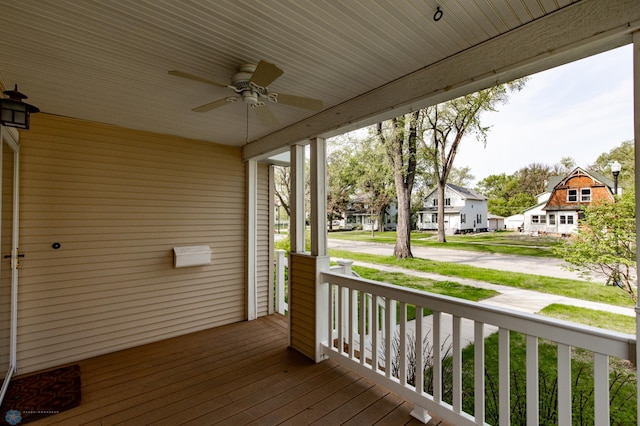 deck with covered porch, ceiling fan, and a residential view