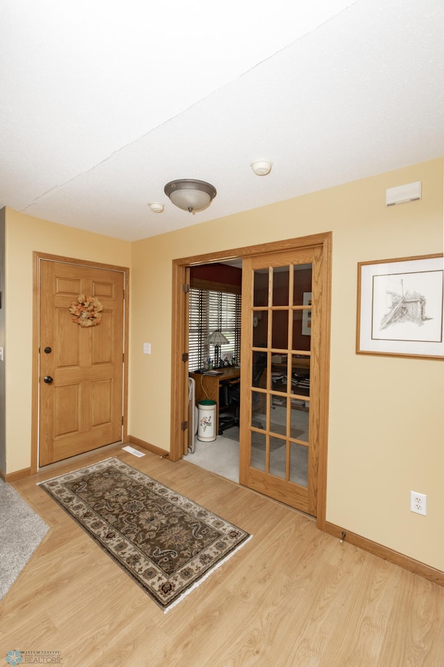 entryway with wood finished floors and baseboards