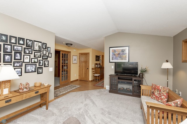 living area featuring carpet floors, vaulted ceiling, and baseboards