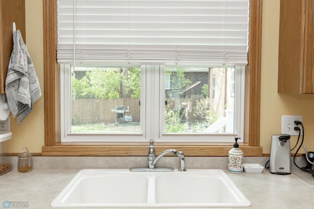 kitchen view of a sink and light countertops