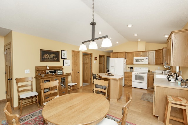dining space featuring lofted ceiling and light wood finished floors