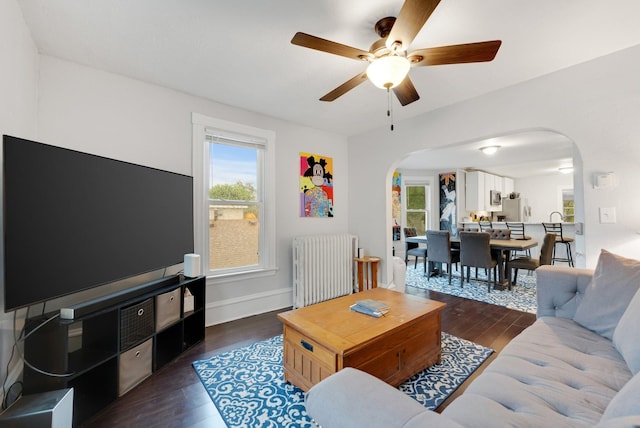 1925 Glenwood Ave, Minneapolis, MN 55405 - living area featuring arched walkways, radiator heating unit, a ceiling fan, and dark wood-style floors