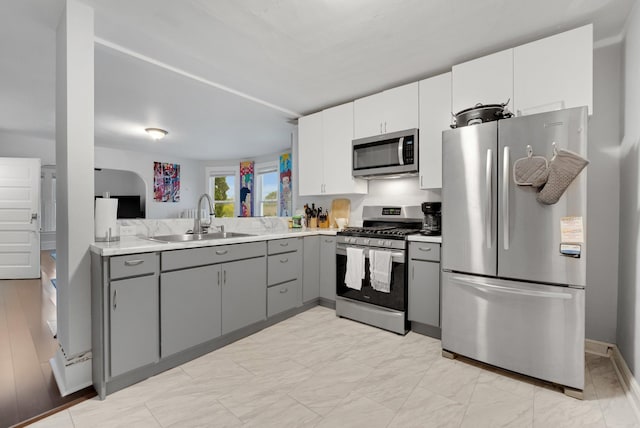 1925 Glenwood Ave, Minneapolis, MN 55405 - kitchen featuring appliances with stainless steel finishes, gray cabinetry, a sink, light countertops, and baseboards
