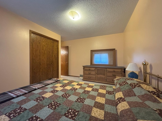 bedroom with a textured ceiling and a closet