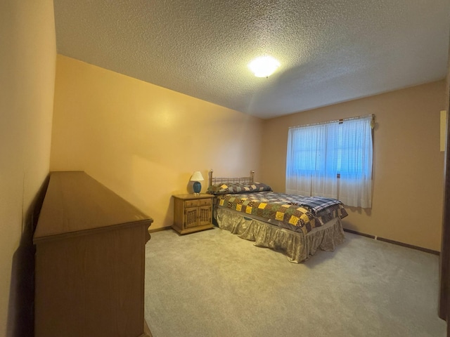 bedroom featuring a textured ceiling, carpet floors, and baseboards