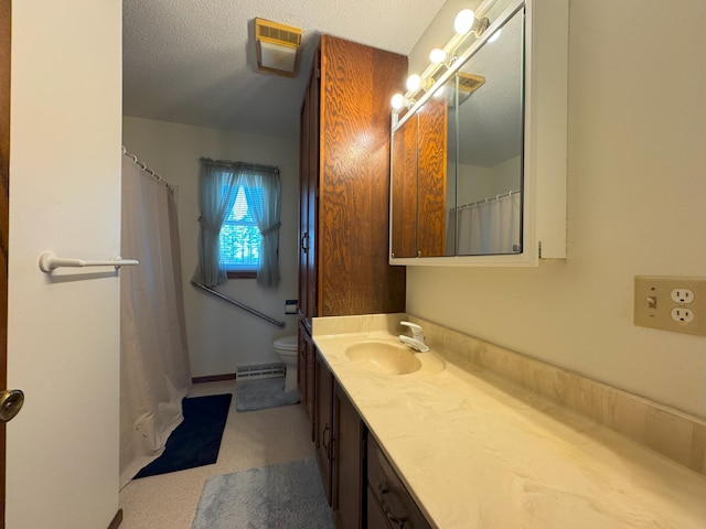 bathroom featuring vanity, toilet, and a textured ceiling