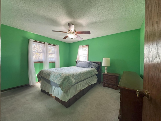 carpeted bedroom with a textured ceiling and a ceiling fan