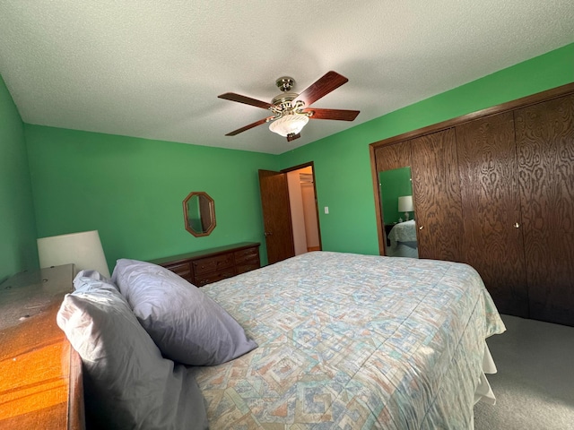 bedroom featuring a textured ceiling, ceiling fan, carpet, and a closet