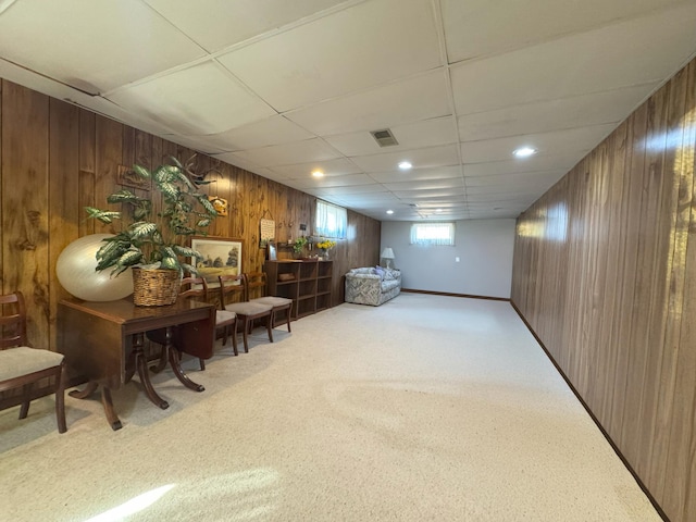 living area featuring wooden walls and carpet