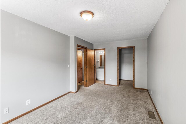 1260 Ferndale St N, Maplewood, MN 55119 - unfurnished bedroom featuring carpet, baseboards, a walk in closet, a textured ceiling, and a closet