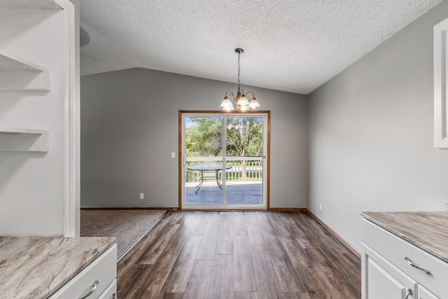 1260 Ferndale St N, Maplewood, MN 55119 - unfurnished dining area with a textured ceiling, a chandelier, dark wood-type flooring, lofted ceiling, and baseboards