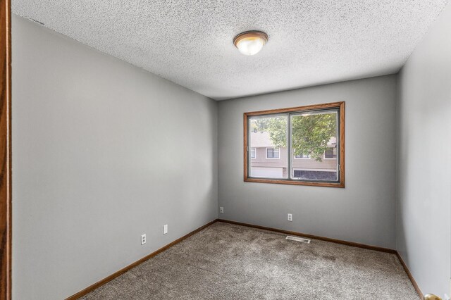 1260 Ferndale St N, Maplewood, MN 55119 - empty room featuring carpet flooring, baseboards, and a textured ceiling
