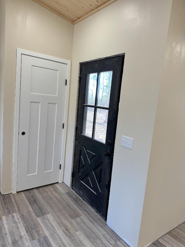 doorway with wood finished floors and wood ceiling