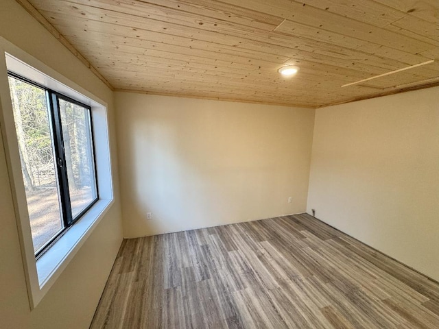 unfurnished room with wood ceiling and wood finished floors
