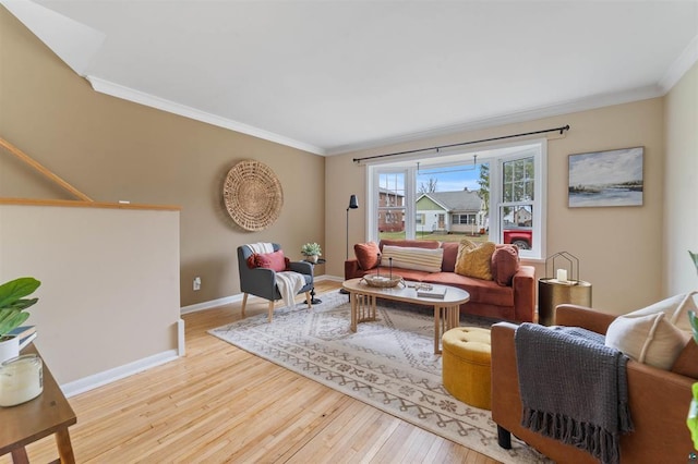 living area with crown molding, baseboards, and hardwood / wood-style floors