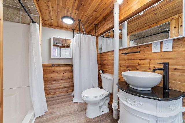 full bath featuring toilet, wood finished floors, a sink, and curtained shower
