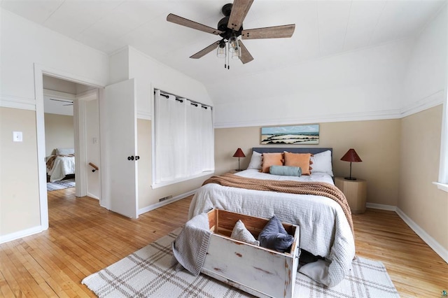 bedroom with vaulted ceiling, ceiling fan, baseboards, and light wood-style floors