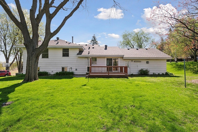 rear view of house with a wooden deck and a lawn