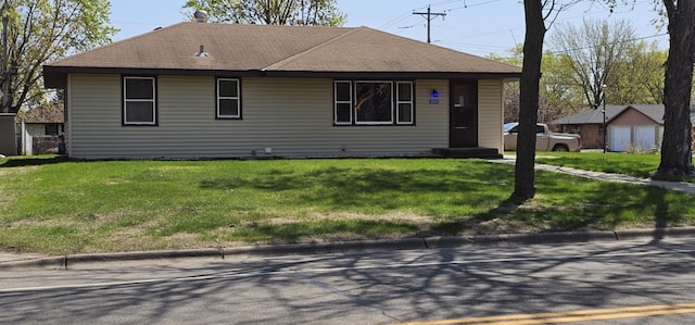 view of front facade featuring a front yard, entry steps, and roof with shingles