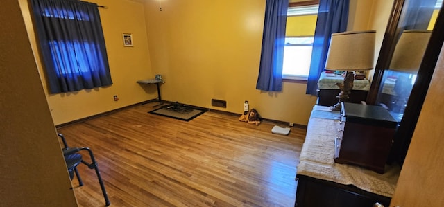 exercise area featuring wood finished floors and baseboards
