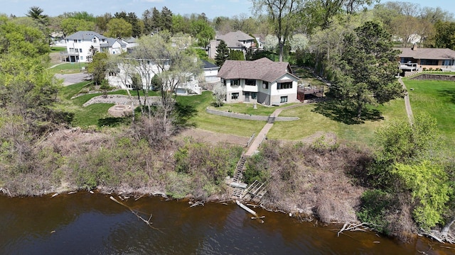 aerial view of residential area featuring a large body of water and a tree filled landscape