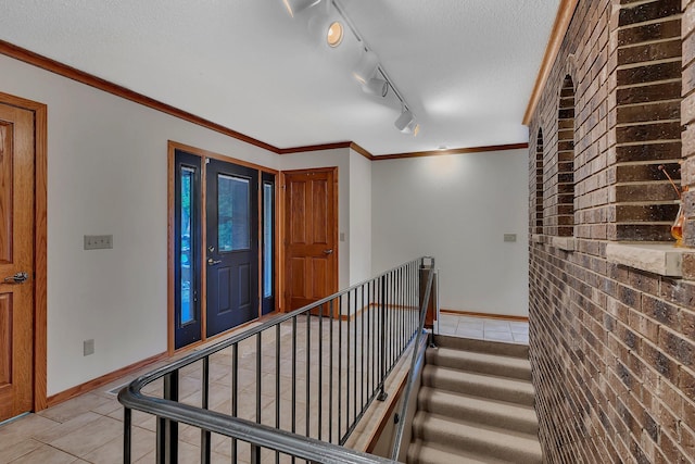 22 13th St S, Sauk Rapids, MN 56379 - entryway with light tile patterned floors, baseboards, a textured ceiling, rail lighting, and crown molding