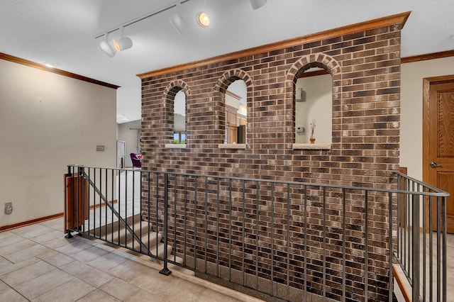 22 13th St S, Sauk Rapids, MN 56379 - hallway with an upstairs landing, ornamental molding, baseboards, tile patterned flooring, and rail lighting