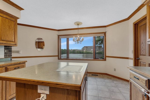 22 13th St S, Sauk Rapids, MN 56379 - kitchen featuring a center island, brown cabinets, baseboards, crown molding, and light tile patterned floors