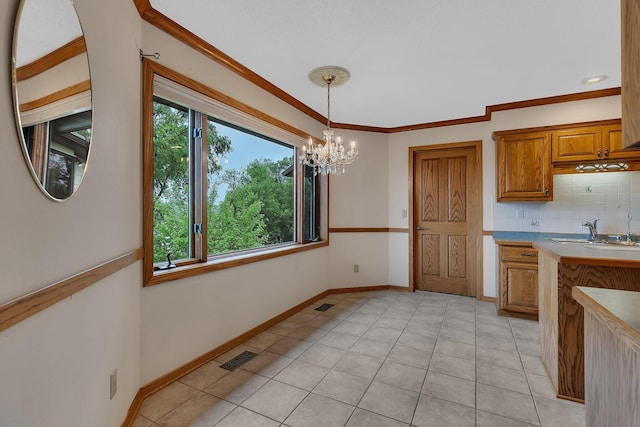 22 13th St S, Sauk Rapids, MN 56379 - kitchen featuring a sink, a chandelier, brown cabinets, hanging light fixtures, and backsplash