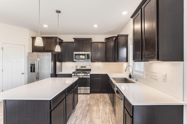 7145 208th Cv N, Forest Lake, MN 55025 - kitchen with appliances with stainless steel finishes, a sink, light wood-type flooring, a kitchen island, and dark brown cabinetry