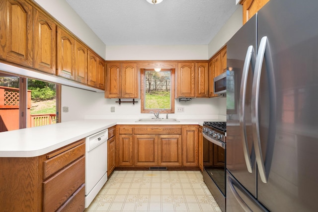 kitchen featuring a sink, brown cabinetry, and appliances with stainless steel finishes