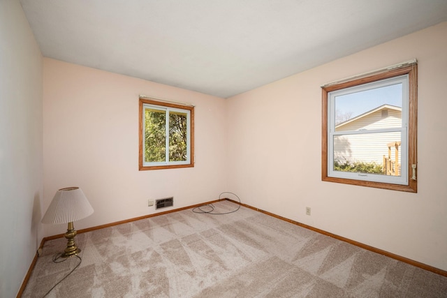 unfurnished room with carpet, baseboards, and visible vents