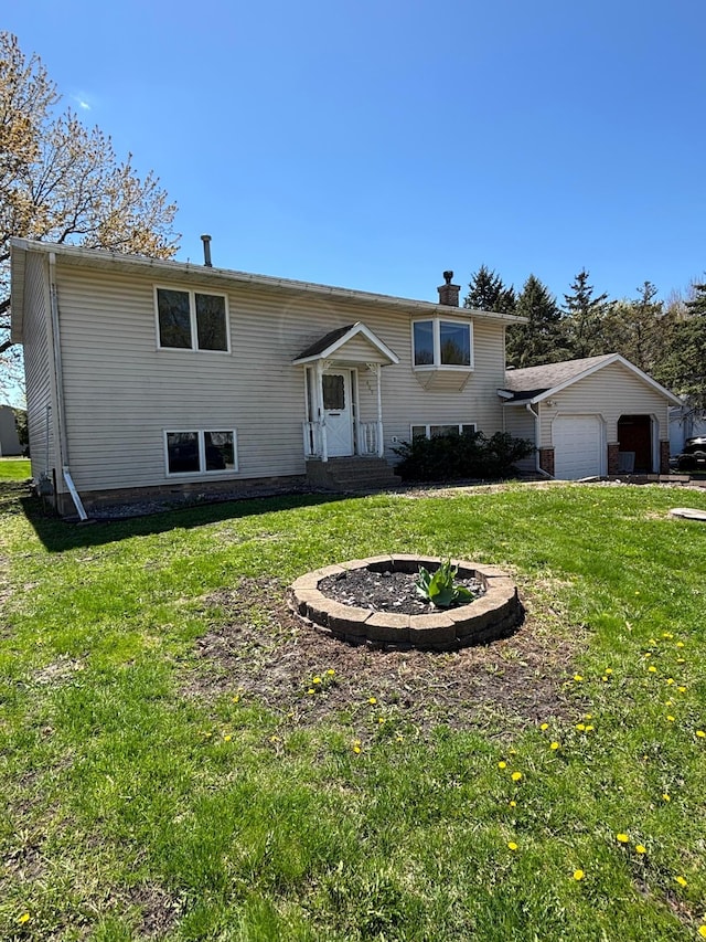 409 4th St NE, Hayfield, MN 55940 - split foyer home featuring an attached garage, a front yard, and a chimney