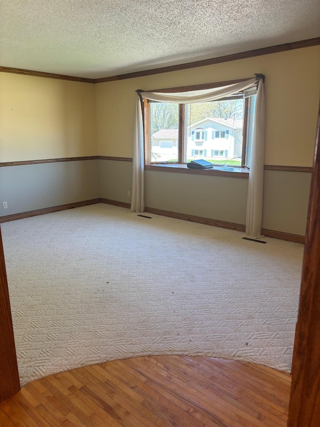 409 4th St NE, Hayfield, MN 55940 - unfurnished room with a textured ceiling, crown molding, wood finished floors, and baseboards