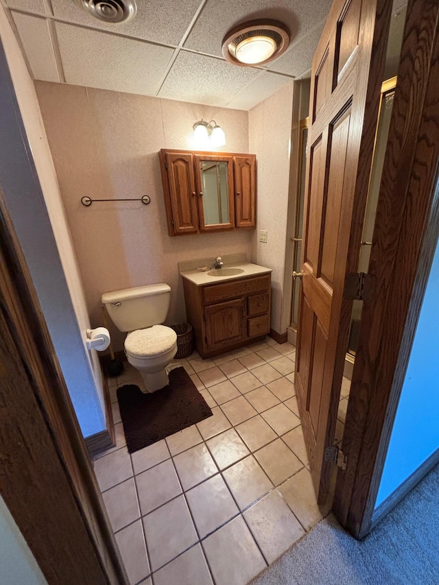 409 4th St NE, Hayfield, MN 55940 - bathroom with toilet, vanity, tile patterned floors, and a paneled ceiling
