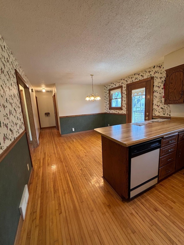 409 4th St NE, Hayfield, MN 55940 - kitchen with wallpapered walls, white dishwasher, a textured ceiling, wainscoting, and a chandelier