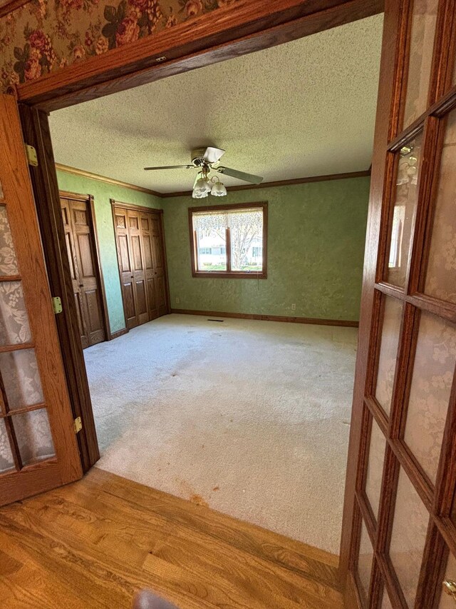 409 4th St NE, Hayfield, MN 55940 - empty room with crown molding, a textured ceiling, light colored carpet, and ceiling fan
