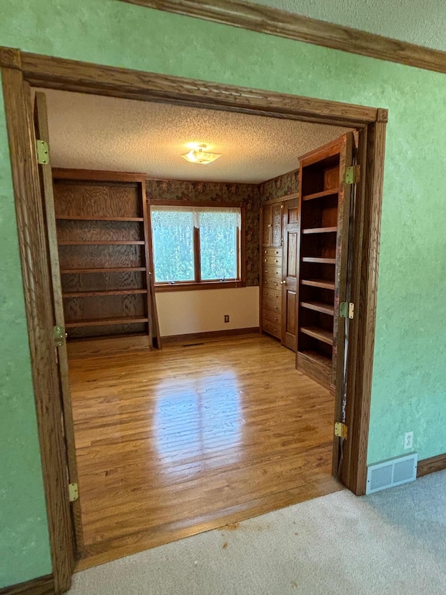 409 4th St NE, Hayfield, MN 55940 - unfurnished bedroom featuring a textured ceiling, a textured wall, wood finished floors, and baseboards