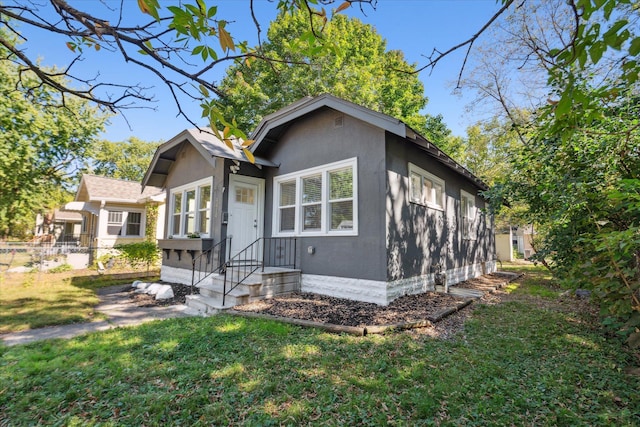 3410 Russell Ave N, Minneapolis, MN 55412 - bungalow-style house with stucco siding, fence, and a front lawn