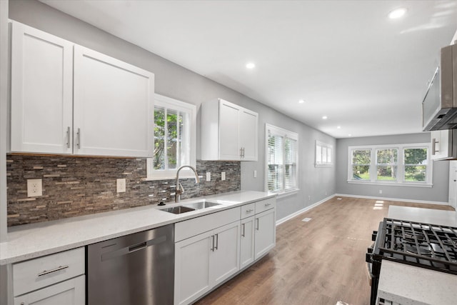 3410 Russell Ave N, Minneapolis, MN 55412 - kitchen with stainless steel dishwasher, a sink, plenty of natural light, backsplash, and recessed lighting