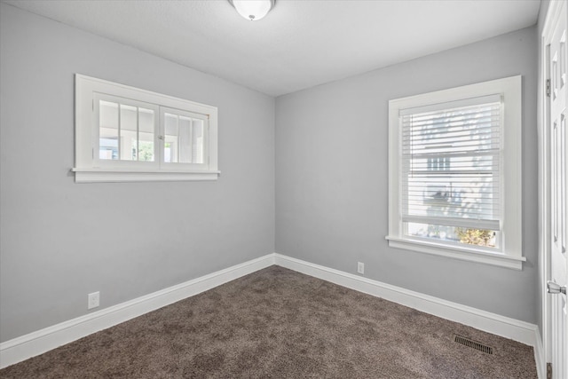 3410 Russell Ave N, Minneapolis, MN 55412 - empty room featuring healthy amount of natural light, dark colored carpet, and baseboards