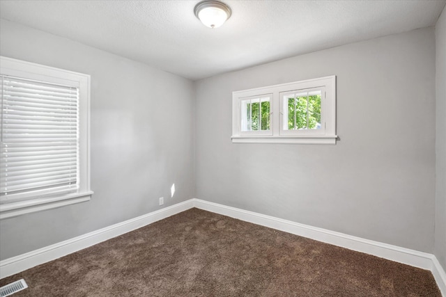 3410 Russell Ave N, Minneapolis, MN 55412 - empty room featuring dark carpet, baseboards, and a textured ceiling