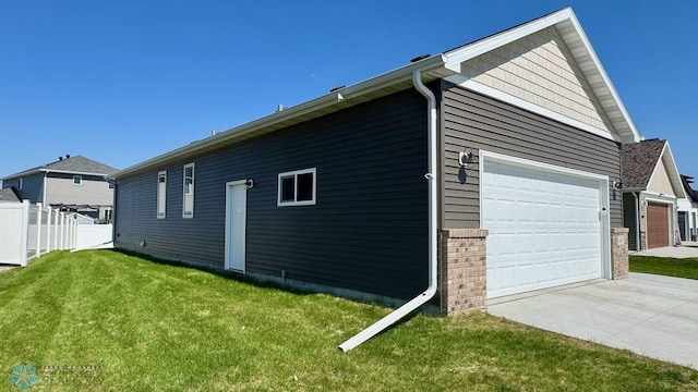 5477 11th St W, West Fargo, ND 58078 - view of home's exterior featuring a lawn, driveway, a garage, and fence