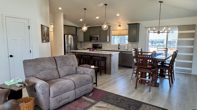 5477 11th St W, West Fargo, ND 58078 - living room with an inviting chandelier, lofted ceiling, light wood-type flooring, and recessed lighting