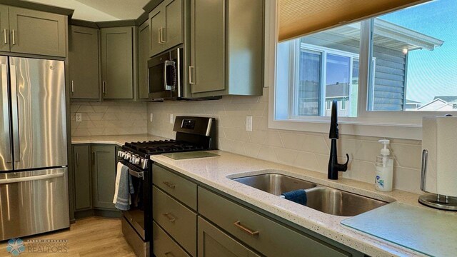 5477 11th St W, West Fargo, ND 58078 - kitchen featuring appliances with stainless steel finishes, plenty of natural light, tasteful backsplash, and a sink