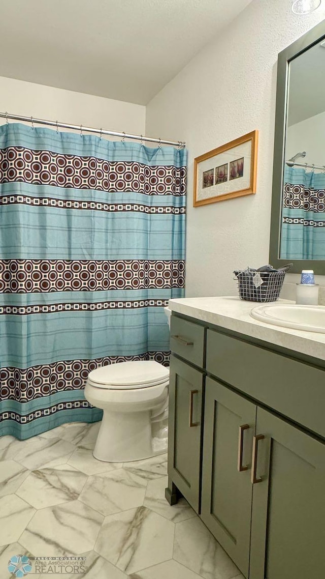 5477 11th St W, West Fargo, ND 58078 - full bath with toilet, marble finish floor, vanity, and a shower with shower curtain